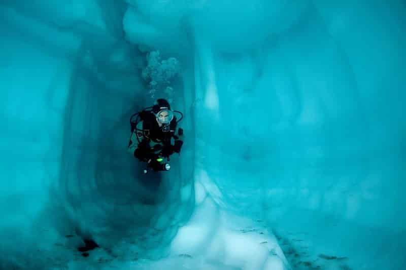 Subacqueo all'interno di una grotta di ghiaccio, lago Sassolo, valle del Sambuco, Ticino, Svizzera