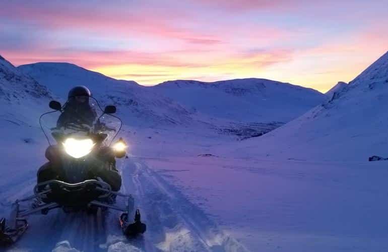 Motoslitta di sera durante un'escursione di un'intera giornata a Tromsø