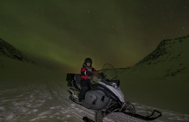 Motoslitta a Tromsø con l'aurora boreale sullo sfondo