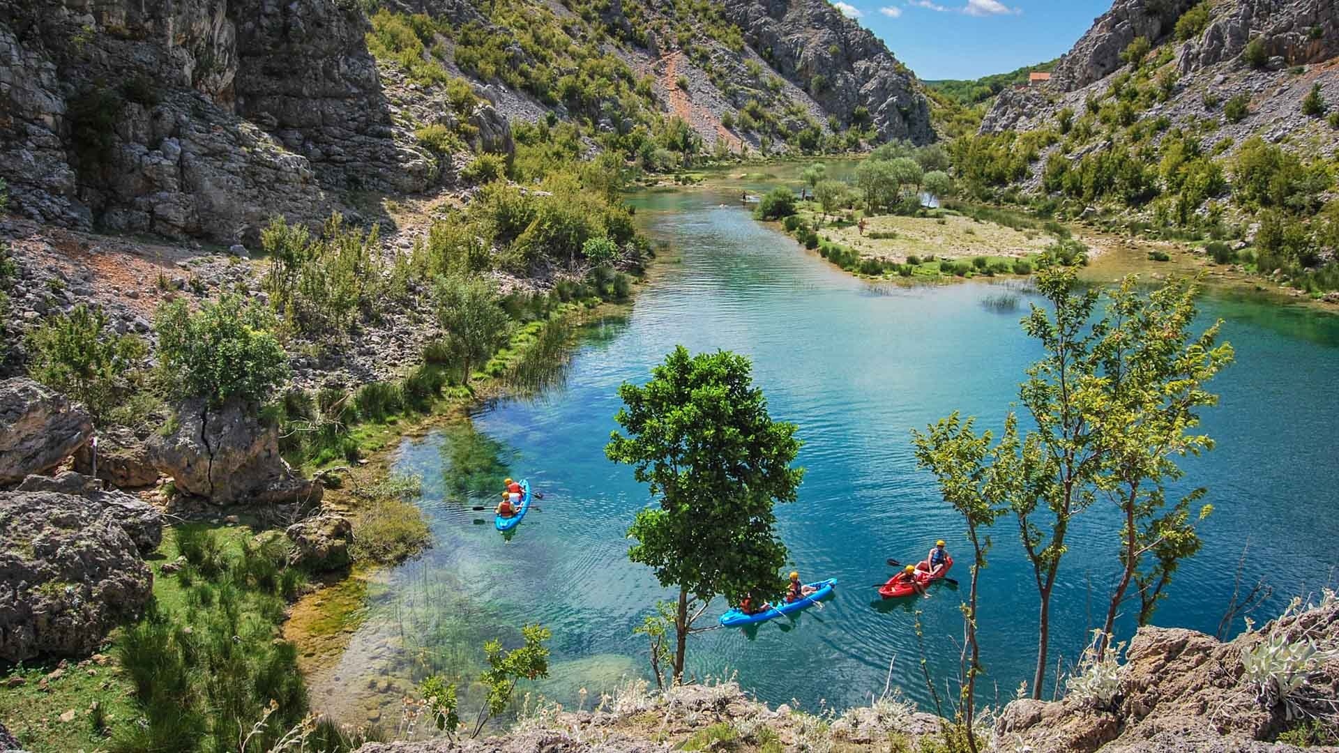 Kayakisti in un fiume limpido e turchese nella regione croata della Dalmazia.