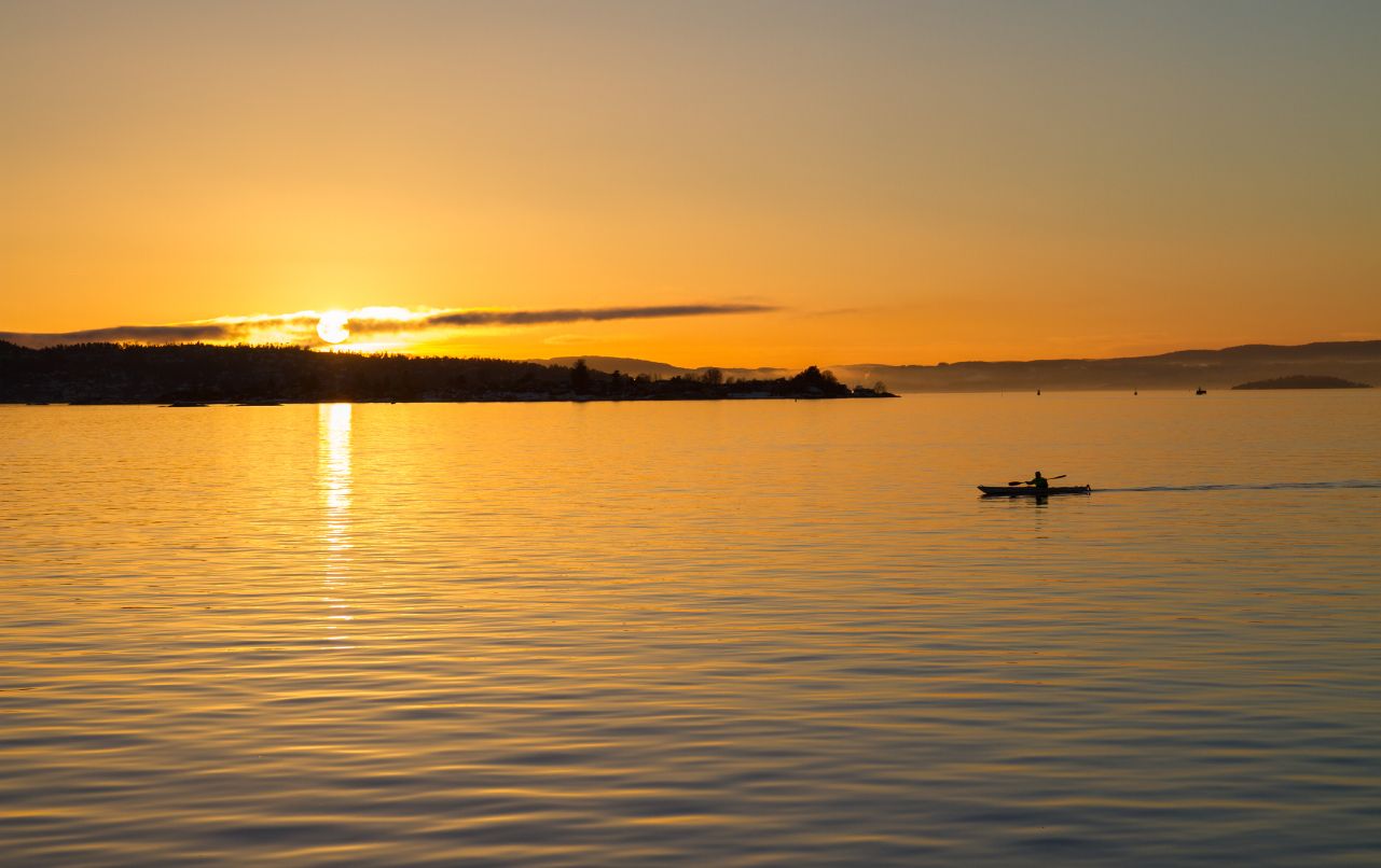 Un kayaker solitario al tramonto sull'Oslofjord, Norvegia