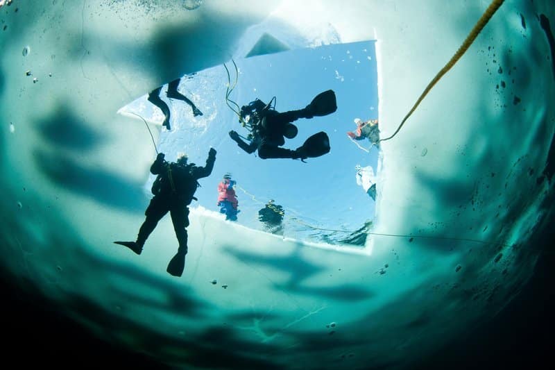 ice-divers-enter-the-water-in-morrison-s-quarry-in-quebec-canada