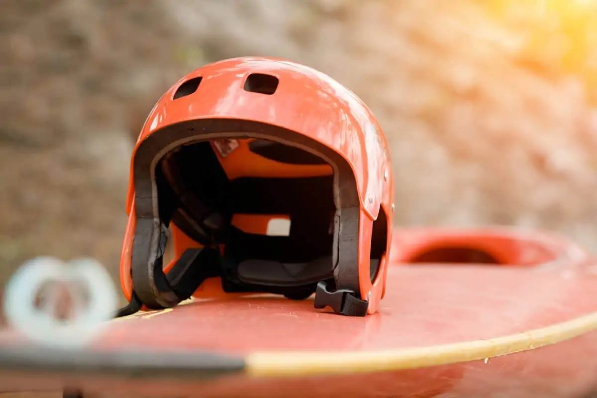 Casco rosso per sport acquatici seduto su un kayak