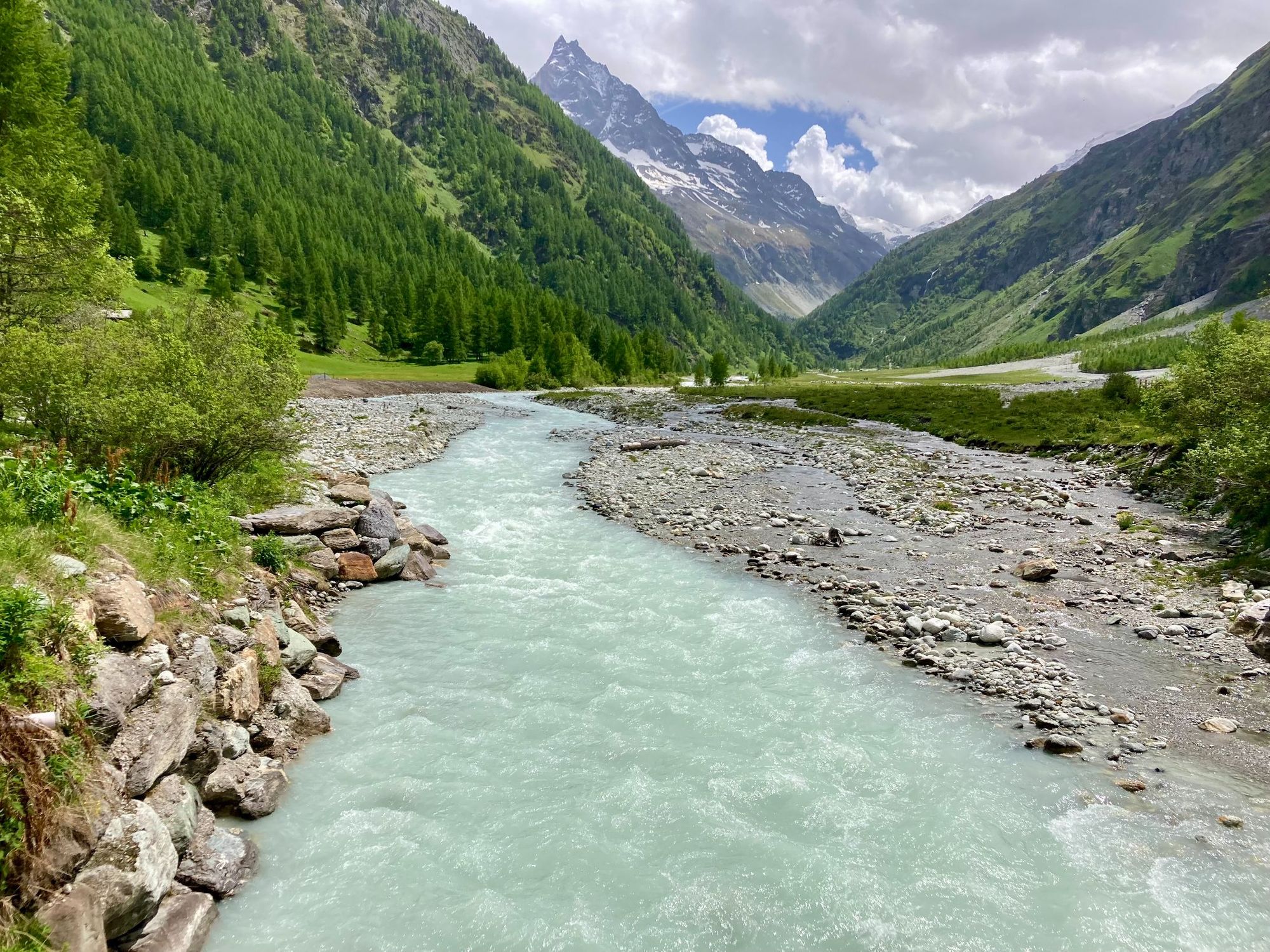 Un fiume glaciale e il verde delle montagne all'ingresso della città di Zinal. Foto: Getty