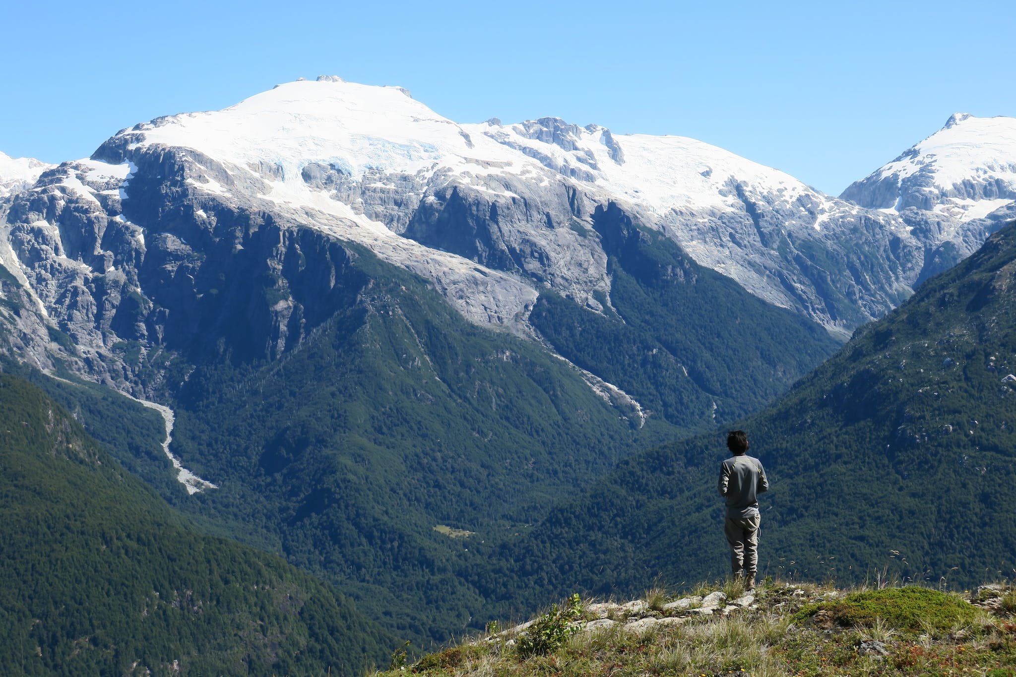 Un uomo guarda le montagne boscose della Valle del Ventisquero, nella Patagonia cilena.