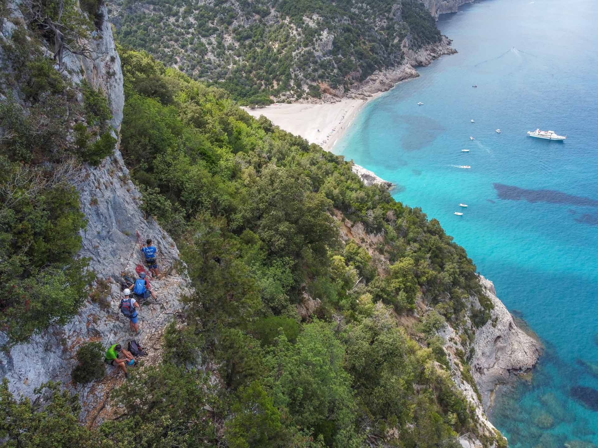 Escursionisti abbracciano la scogliera mentre percorrono il sentiero Selvaggio Blu, Italia.
