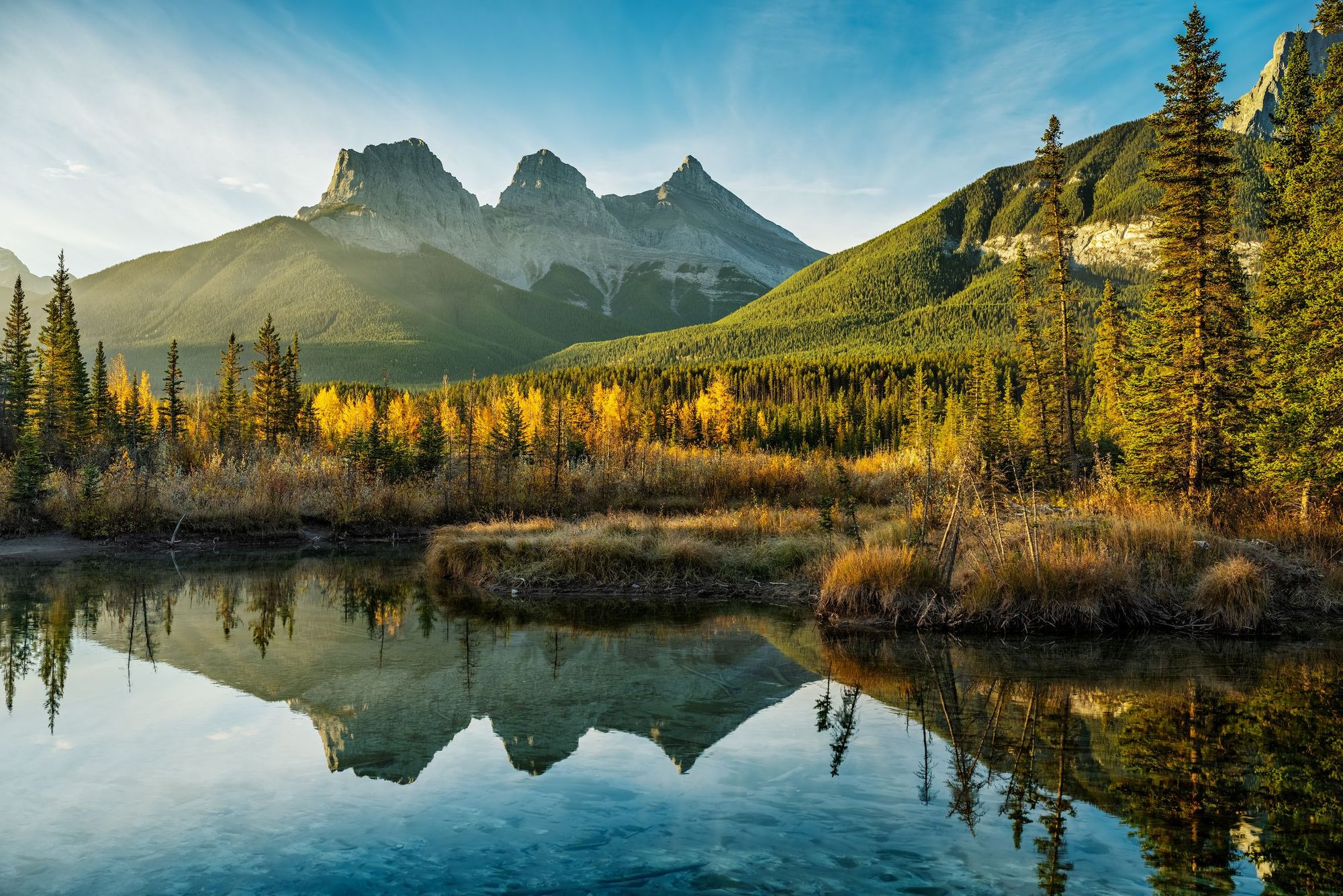 Alba sulle Tre Sorelle, riflesso nel Policeman Creek, Canmore, Alberta. Foto: Getty